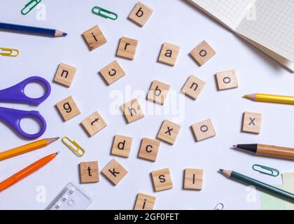 Schreibwaren für die Schule, viele verschiedene Holzbriefe liegen auf weißem Hintergrund. Konzept Zurück in die Schule. Draufsicht, flach liegend. Stockfoto