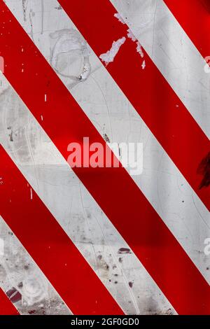 Verblasste rote und weiße diagonale Stechstreifen auf flachem Stahlblech - Warnschild Stockfoto