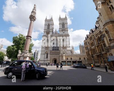 London, Greater London, England, August 10 2021: Taxifahrer macht eine Pause mit der gotischen Westminster Abbey dahinter und Deans Yard Area rechts. Stockfoto