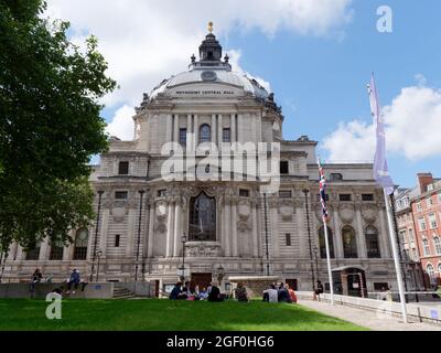 London, Greater London, England, 10 2021. August: Eine Gruppe sitzt auf dem Green der Vereinten Nationen vor der Central Hall Westminster, auch Methodist Central Hall genannt. Stockfoto