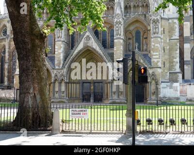 London, Greater London, England, August 10 2021: Verschlungene Fassade und Türen der gotischen Westminster Abbey vom Parliament Square aus gesehen. Stockfoto