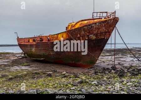 Ein rostiges Schiffswrack im Schlamm der Walney Kanal, von der Straße auf Roa Island, Cumbria, England, UK gesehen Stockfoto