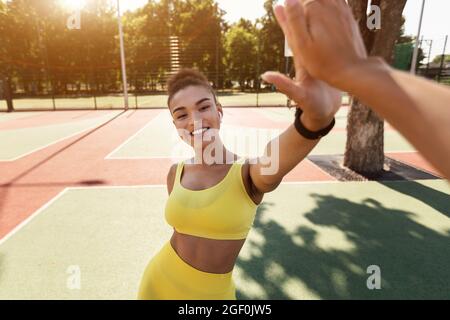 Sportliche schwarze Frau, die nach dem Training hohe fünf gibt Stockfoto