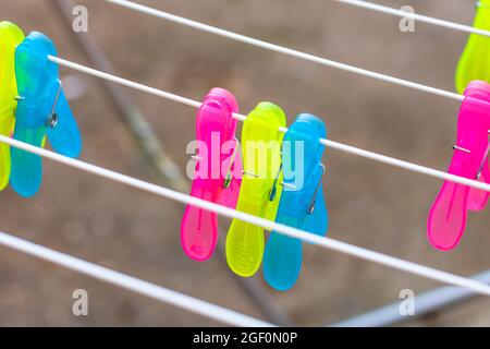 Eine Nahaufnahme von bunten Plastikklammern auf leeren Metalltrocknern Stockfoto