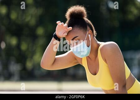 Frau trägt eine schützende Gesichtsmaske während des Trainings Stockfoto