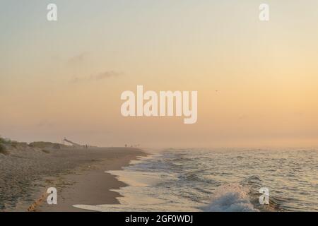 Nebliger Sonnenaufgang über dem Meer. Pastelltöne. Wunderschöne Landschaft. Sandstrand des Ozeans. Sonnenuntergang am Himmel. Wolken. Küste. Stockfoto