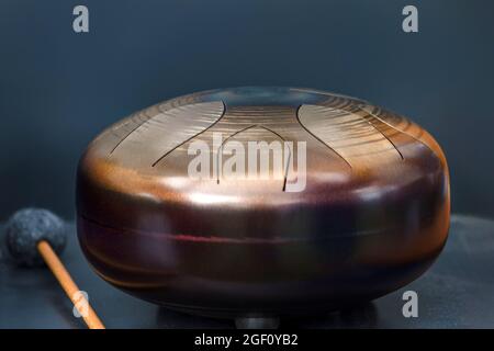 Stahlzunge, Trommel. Klangschale, Stahltrommel und Drumsticks. Instrument für Klangwellentherapie und Meditation, Heilung. Stockfoto