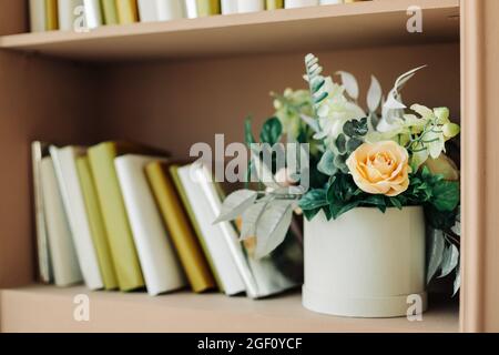 Interieur eines hellen Studio-Zimmer, dekoriert mit Frühlingsblumen, ein Regal mit Büchern, antikes Dekor, Studio, Dekor Stockfoto