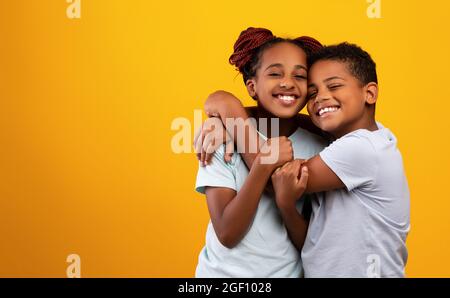 Emotionaler afroamerikanischer Bruder und Schwester umarmen und lächeln Stockfoto