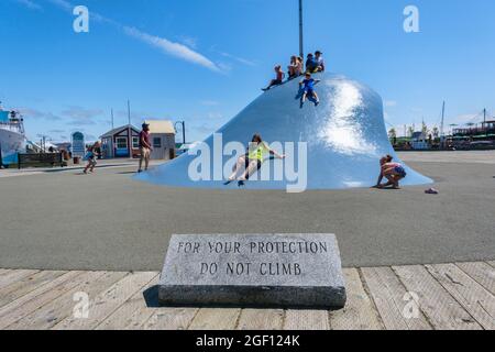 Halifax, Nova Scotia, Kanada - 11. August 2021: Kinder klettern Donna Hiebert die Wave Skulptur am Hafen Stockfoto