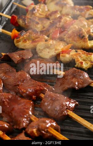 Eine Nahaufnahme des saftigen rohen Fleisches auf den Holzspießen, die gegrillt werden Stockfoto