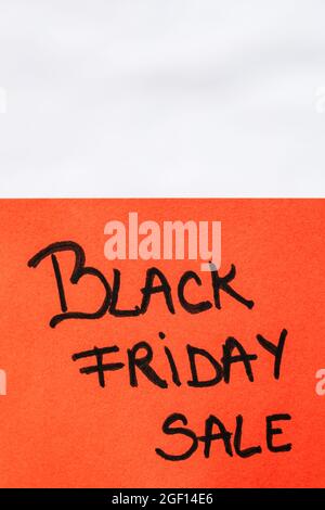 Ein handschriftlicher Text mit der Aufschrift „Black Friday Sale“ auf einem orangefarbenen Papier Stockfoto
