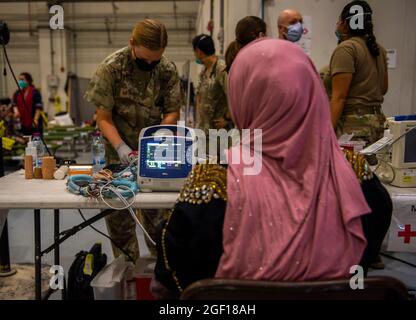 Al Udeied Air Base, Katar. August 2021. Die Luftwaffe der USA und die 379. Expeditionary Medical Group leisten medizinische Versorgung für evakuierte Afghanistans in einem Hangar am 19. August 2021 auf dem Luftwaffenstützpunkt Al Udeied, Katar. Quelle: Planetpix/Alamy Live News Stockfoto