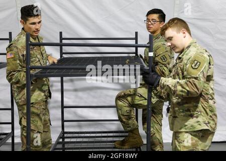 Grafenwoehr, Deutschland. August 2021. US-Soldaten mit der 41. Field Artillery Brigade haben am 22. August 2021 in Grafenwoehr, Deutschland, Betten für afghanische Flüchtlinge eingerichtet. Das Ausbildungsgebiet Grafenwoehr wird im Rahmen der Operation Allies Refuge für Evakuierte aus Afghanistan eine vorübergehende Unterkunft bereitstellen. Quelle: Planetpix/Alamy Live News Stockfoto