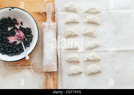 Prozess der Herstellung von süßen Vareniki mit Beeren traditionelle ukrainische Lebensmittel Stockfoto