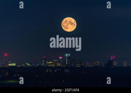 Birmingham, Großbritannien. August 2021. Der Vollmond hängt wie eine riesige Lampe über den Lichtern der Stadt Birmingham, Großbritannien. Dieser August-Vollmond wird den Spitznamen „turgeon“-Mond erhalten. Kredit: Peter Lopeman/Alamy Live Nachrichten Stockfoto