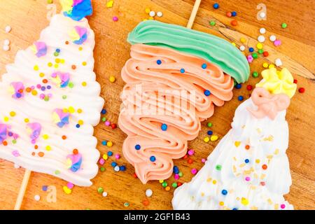 Weihnachtsbaum geformte Meringue Lutscher auf einem Holzhintergrund Stockfoto