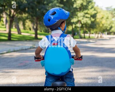 Junge Fahrrad fahren mit Helm und Rucksack. Gesunde Gewohnheit für Kinder. Sommerlager. Sportliche Aktivitäten Stockfoto