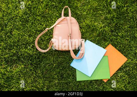 Schulrucksack, Rucksack mit Büchern über das Liegen auf dem Gras Stockfoto