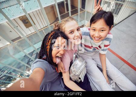 POV-Hochwinkel-Ansicht auf verschiedene Gruppe von Schülerinnen, die zusammen Selfie machen Stockfoto