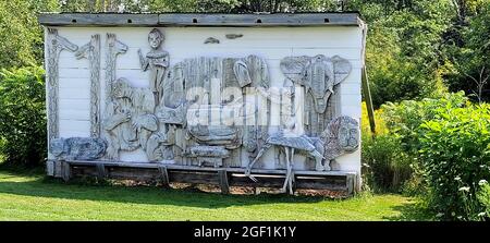 Diese Skulptur mit dem Titel Animal Relief on side of Shed wurde vom amerikanischen Künstler Bernard Langlais geschaffen und befindet sich im Langlais Sculpture Preserve in Cushing, Maine. Bernard Langlais (1921 - 1977) war gebürtiger Maine und hatte bis zu seinem Tod im Alter von 56 Jahren ein Studio in Cushing, Maine, unterhalten. Sein künstlerisches Interesse entwickelte er an der Corcoran School. Stockfoto