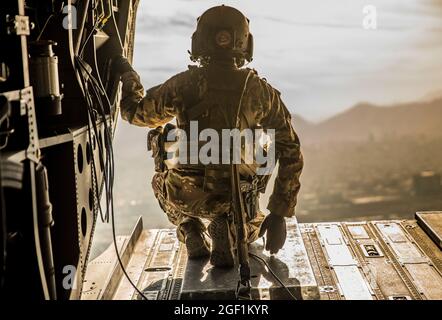 Ein US-Soldat, der der 10. Bergdivision zugewiesen wurde, untersucht den Rücken eines CH-47 Chinooks während eines Fluges über Kabul, Afghanistan, am 30. November 2019. (USA Army Reserve Foto von SPC. Jeffery J. Harris/ veröffentlicht) Stockfoto