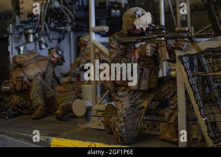 PAZIFIK (Aug 20, 2021) U.S. Marine Corps PFC. David Medina, ein Mitarbeiter eines leichten gepanzerten Fahrzeugs mit Light Armored Reconnaissance Company, Battalion Landing Team 1/1, 11th Marine Expeditionary Unit (MEU), stellt während der Räumung des Bereichs an Bord des Amphibientransportsdocks USS Portland (LPD 27), August 20, Sicherheit ein. Portland, Teil der USS Essex Amphibious Ready Group, ist zusammen mit der 11. MEU im Verantwortungsbereich der 7. US-Flotte tätig, um die Interoperabilität mit Verbündeten und Partnern zu verbessern und als ready Response Force zur Verteidigung von Frieden und Stabilität in der Indo-Pazifik-Region zu dienen. (USA Stockfoto