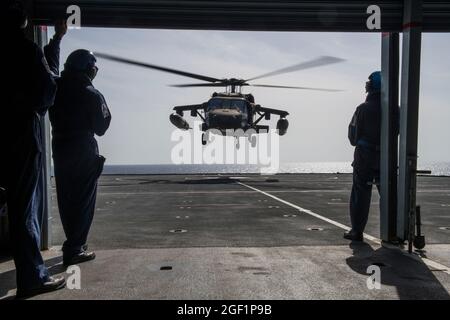 Die Luftbesatzung mit dem 1. Bataillon, dem 228. Luftfahrtregiment, der Joint Task Force-Bravo, dem Soto Cano Air Base, Honduras, führt an Bord des Royal Fleet Auxiliary Wave Knight der Royal Navy in der Karibik, 18. August 2021, eine Qualifikation zur Landung an Deck durch. Qualifikationsmissionen zur Landung auf Deck stellen sicher, dass die Mitglieder der Luftbesatzung im Falle eines Überwassernotfalls, wie z. B. eines abgestürzten Flugzeugs, einer Katastrophenhilfe, einer medizinischen Luftevakuierung oder einer Such- und Rettungsmission über offenem Wasser, reagieren können. (USA Air Force Foto von Tech. Sgt. Marleah Cabano) Stockfoto