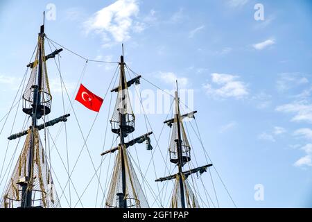 Die Masten des Schiffes mit der türkischen Flagge auf dem Hintergrund des blauen Himmels. Das Konzept von Reisen und Freiheit Stockfoto