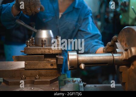 Die Hände des Meisters drehen den Griff auf der Drehbank. Stockfoto