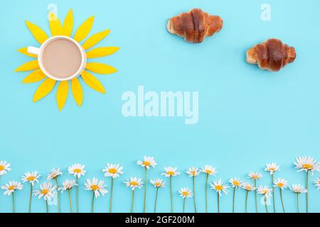 Kreatives Konzept von Guten Morgen. Kaffee, Croissants und Kamillenblumen auf blauem Hintergrund. Frühstück für gute Laune. Speicherplatz kopieren. Stockfoto