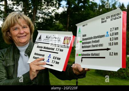 Wildemann, Deutschland. August 2021. Die Geschäftsführerin des Harzklub e.V., Annett Drache, zeigt vor dem Clubhaus frisch gedruckte Schilder für die Wanderwege im Harz. Wandern im Harz wäre sicherlich nur halb so schön, wenn es kein ausgedehntes Wegenetz, Schilder am richtigen Ort und gute Wanderkarten gäbe! Um dies zu gewährleisten, sind täglich viele ehrenamtliche Mitglieder des Harzklubs im Einsatz. Kredit: Frank May/dpa/Alamy Live Nachrichten Stockfoto