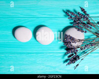 Drei weiße Zen-Steine in einer Reihe in einer Linie auf blauem Hintergrund. Stockfoto