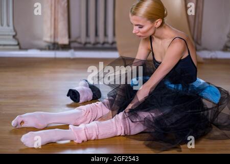 Balletttänzerin führt Dehnübungen durch, bevor sie eine Tanzprobe beginnt. Stockfoto