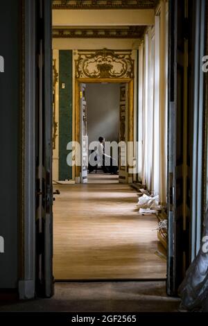 Solo Ballerina tanzt in den Hallen eines alten russischen Palastes, gekleidet in ein kunstvolles Gewand Stockfoto