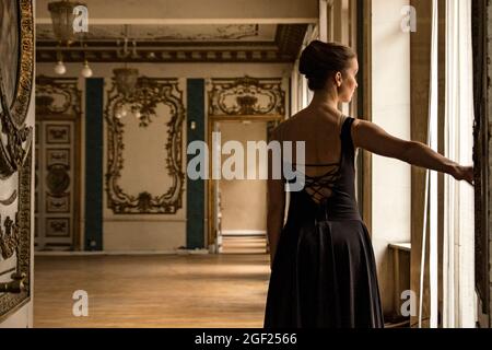 Solo Ballerina tanzt in den Hallen eines alten russischen Palastes, gekleidet in ein kunstvolles Gewand Stockfoto