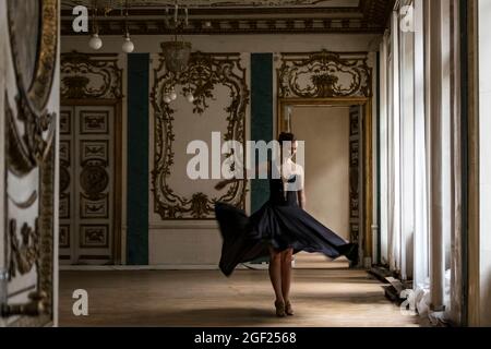 Solo Ballerina tanzt in den Hallen eines alten russischen Palastes, gekleidet in ein kunstvolles Gewand Stockfoto