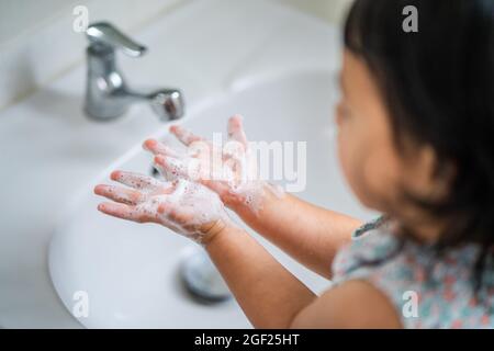 Südostasiatische Mädchen waschen ihre Hände an der Toilette, um Viren und Keime zu verhindern Stockfoto