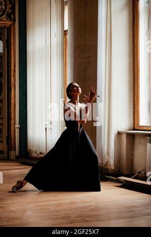 Solo Ballerina tanzt in den Hallen eines alten russischen Palastes, gekleidet in ein kunstvolles Gewand Stockfoto