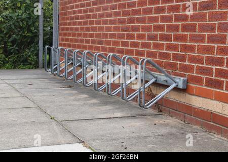 Leerer Fahrradständer, Parkplatz für Fahrräder auf einem Backsteinmauer Hintergrund Stockfoto