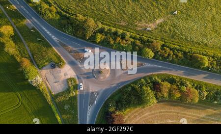 Luftaufnahme von ländlichen Straßen Kreisverkehr in der Abendsonne. Stockfoto