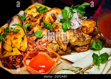 Shish Kebab mit gegrilltem Gemüse, Lavasch und Saucen. Nahaufnahme, selektiver Fokus Stockfoto