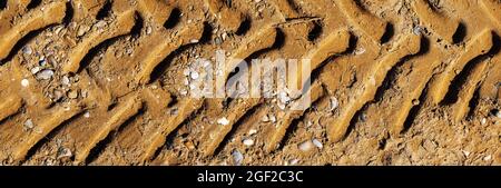 Draufsicht auf der Reifenpanne im Sand. Panorama der Reifenpanne, geeignet für Header oder Banner. Geländefahrspuren am Strand bei starker Sonneneinstrahlung. Stockfoto