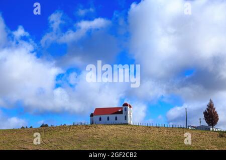 Die historische Ratana Kirche in Raetihi, Neuseeland, steht auf einem Hügel mit einem wunderschönen blauen Himmel im Hintergrund Stockfoto