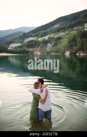 Reifes Paar in der Liebe steht im Wasser in See in der Natur, umarmt. Stockfoto