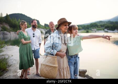 Glückliche Familie mit mehreren Generationen im Sommerurlaub, Wandern am See. Stockfoto