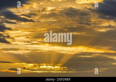 goldene Sonnenstrahlen, die bei Sonnenaufgang durch die Wolken scheinen, Tyndall Effect, Schweiz Stockfoto