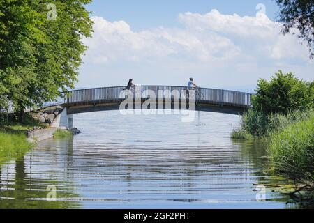 Zwei Radfahrer überqueren die Brücke über den Aach an der Mündung in den Bodensee, Arbon im Thurgau, Schweiz, Schweiz Stockfoto