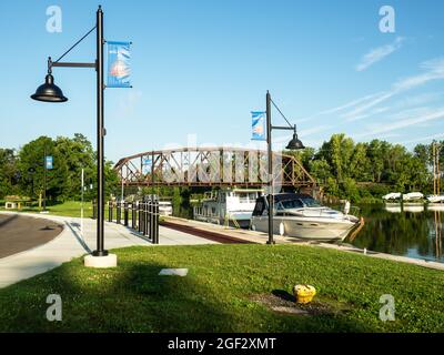 Brewerton, New York, USA. August 22,2021 .Park mit Eisenbahnbrücke über den Oneida Fluss in Brewerton, New York an einem ruhigen Sommermorgen Stockfoto