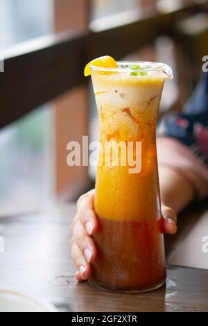 Halten Sie Eistee in einem vermistelten Glas am Tisch fest. Stockfoto